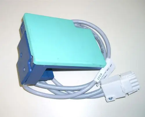 Gasfeuerungsautomat von Remeha mit grünem oberen Teil und grauem Kabel. An einer Seite ist ein weißer Anschluss zu sehen.